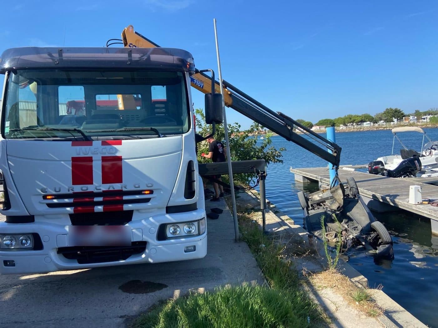 Camion-grue d’un épaviste sortant de l’eau une voiture hors d’usage · Épaviste à Saint-Denis (93)